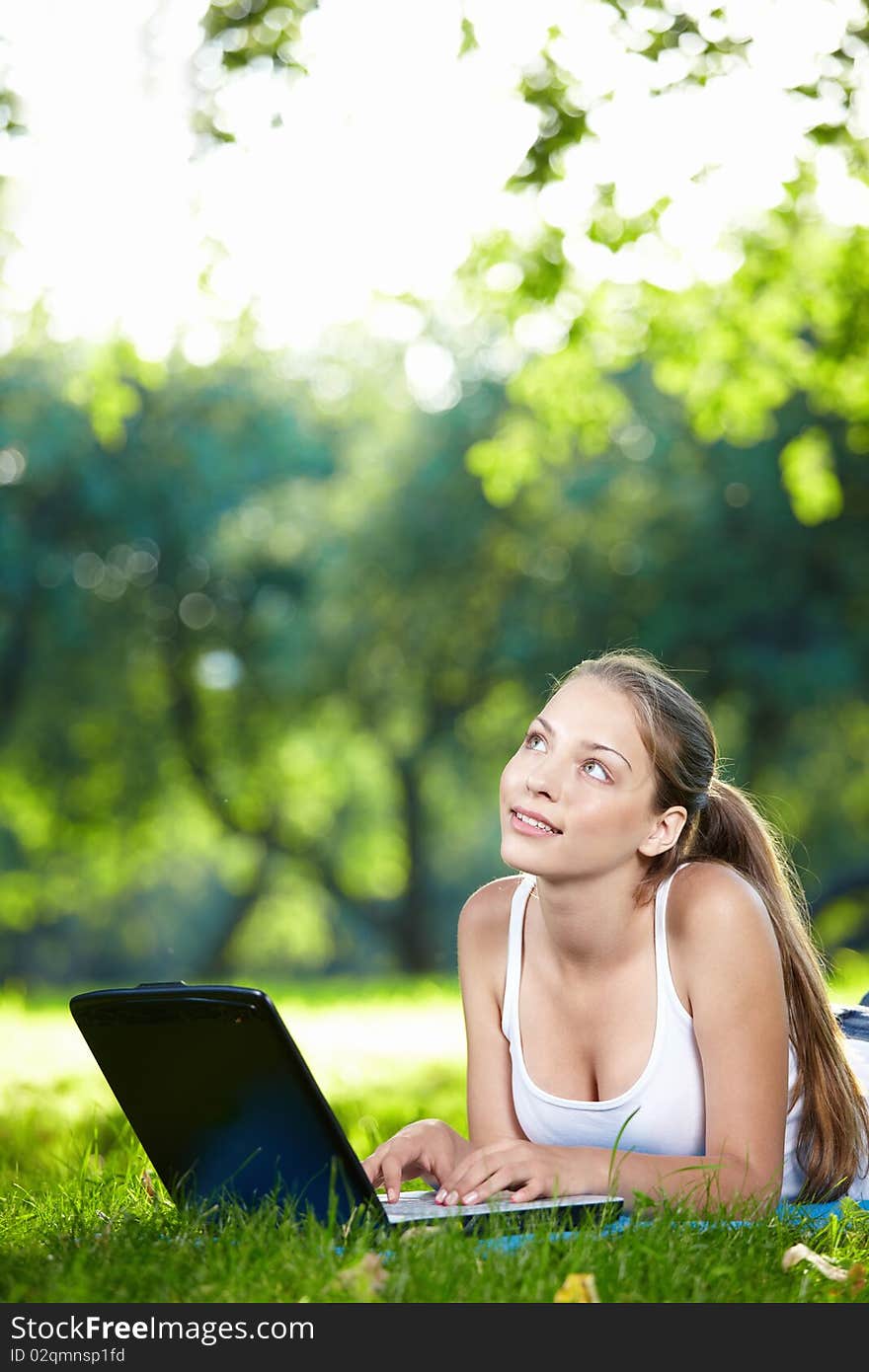 Young beautiful girl with a laptop in the park. Young beautiful girl with a laptop in the park