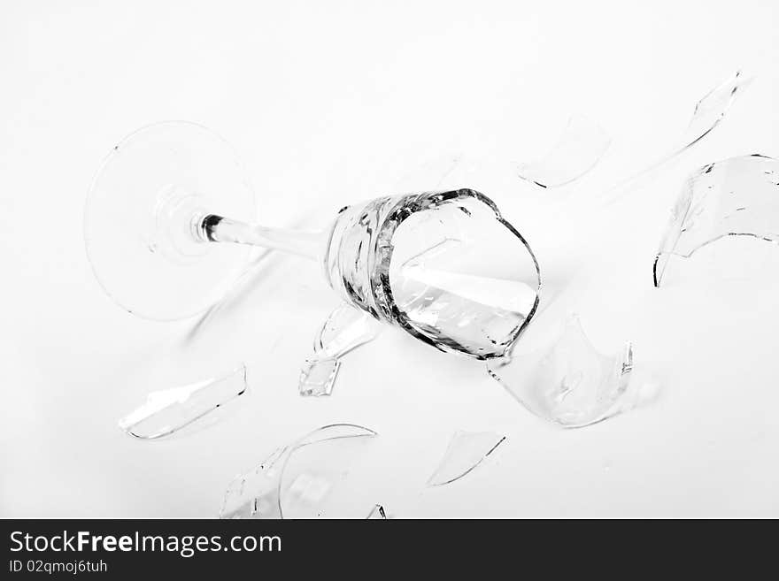 Broken wineglass on the white background. Black and white.