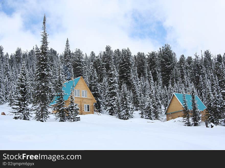 Two wooden houses in the winter in the mountains. Two wooden houses in the winter in the mountains