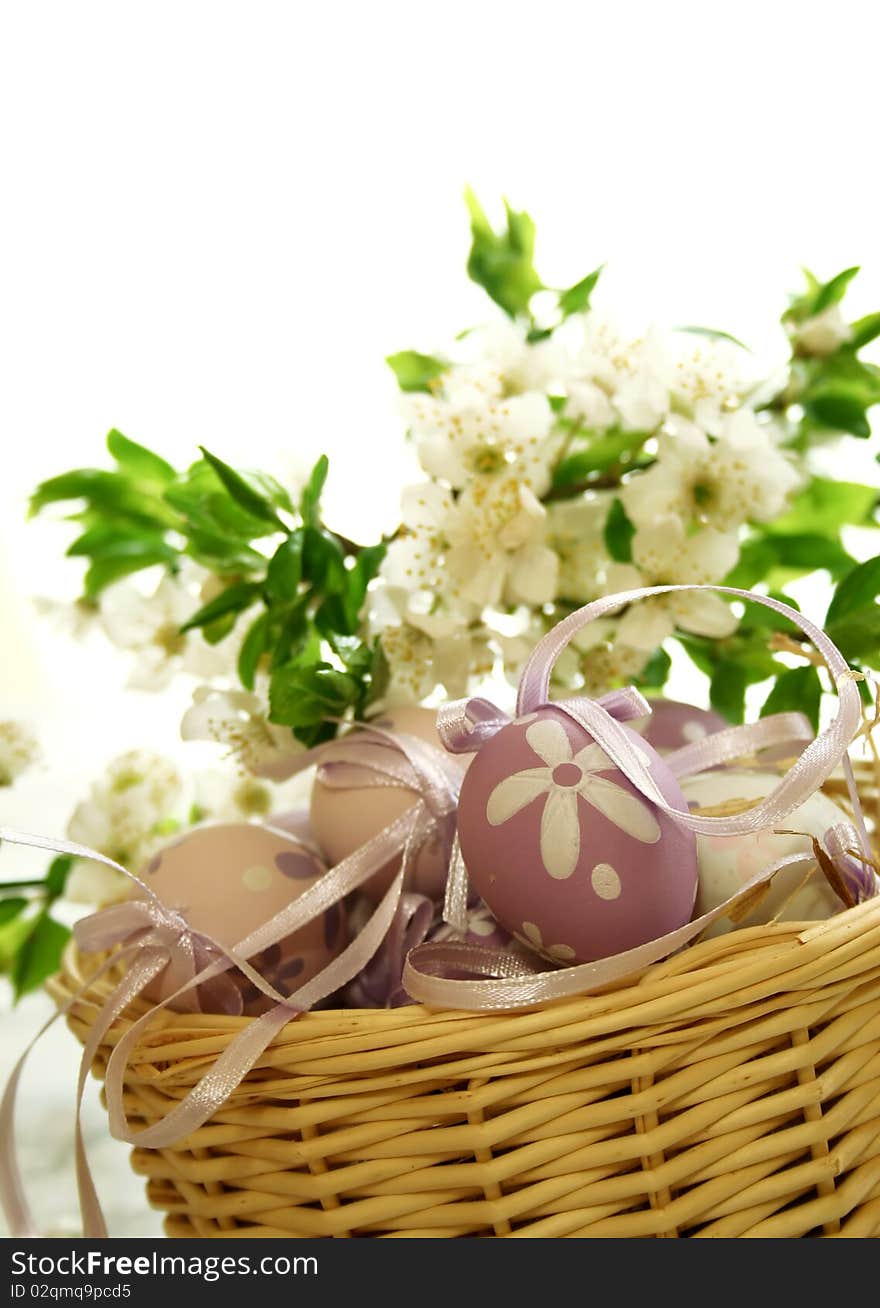 Easter eggs and branch with flowers on white