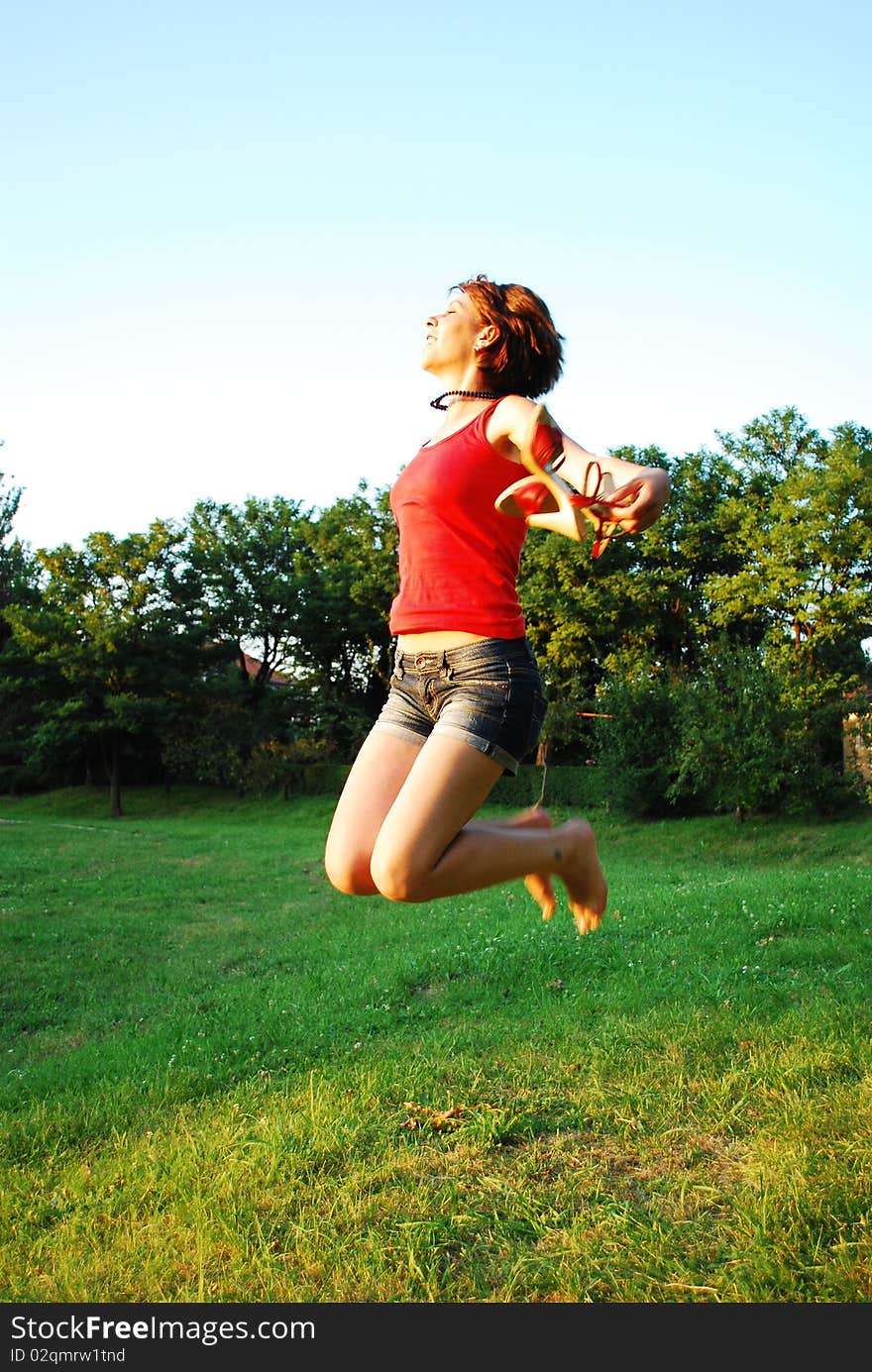 Happy woman jumping on grass