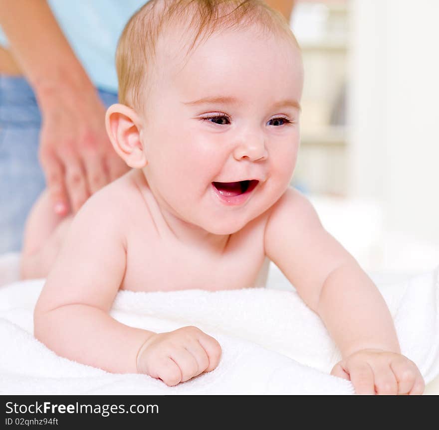 Mother massaging back of beautiful baby - indoors. Mother massaging back of beautiful baby - indoors