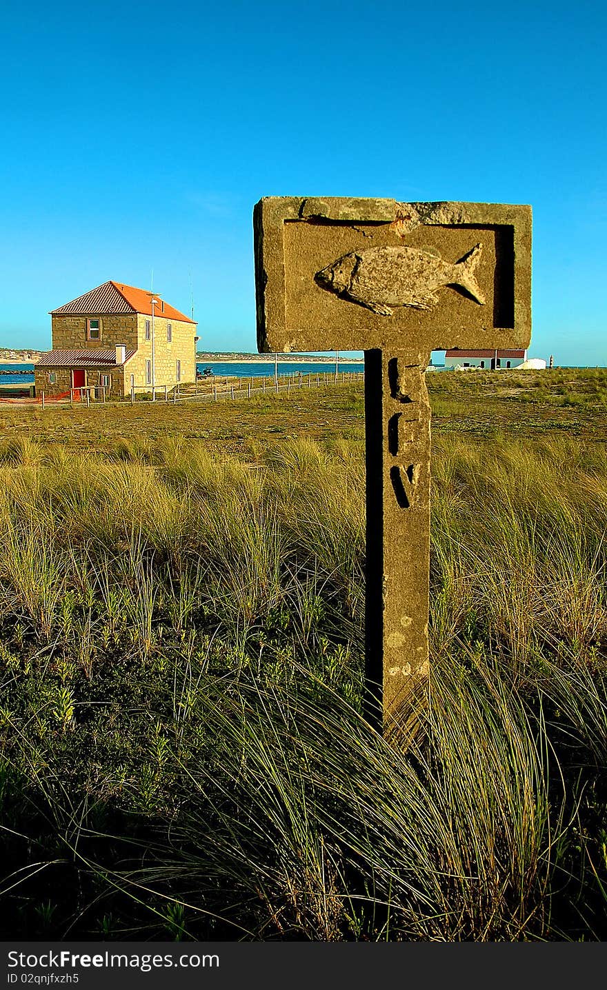 Rock street sign with a house and blue sky on the foreground. Rock street sign with a house and blue sky on the foreground