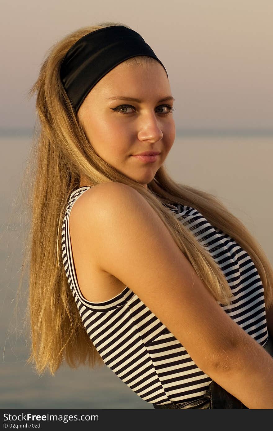 Girl in the sunset lights at the sea