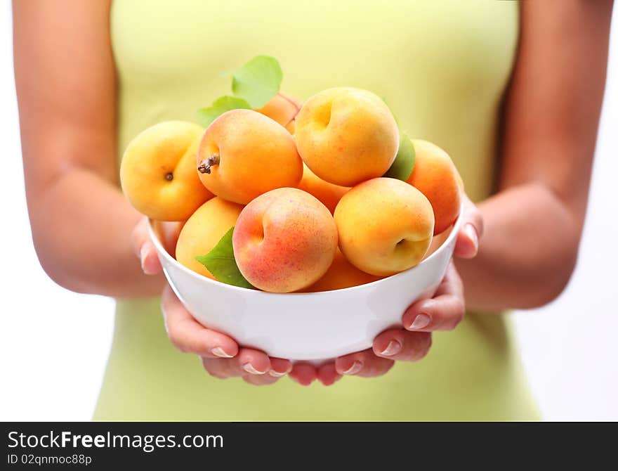 Crockery with ripe apricots in woman hands. Crockery with ripe apricots in woman hands.