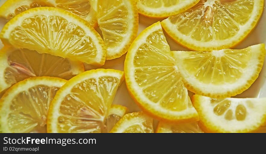 A lot of juicy lemon shares lie on a plate