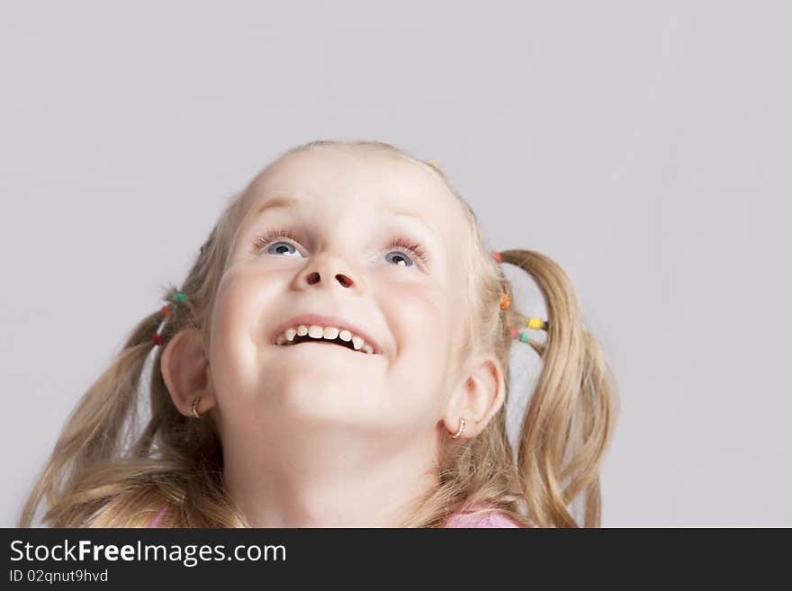 Smiling little blond girl making her head llifted with laughing positive expression isolated. Smiling little blond girl making her head llifted with laughing positive expression isolated