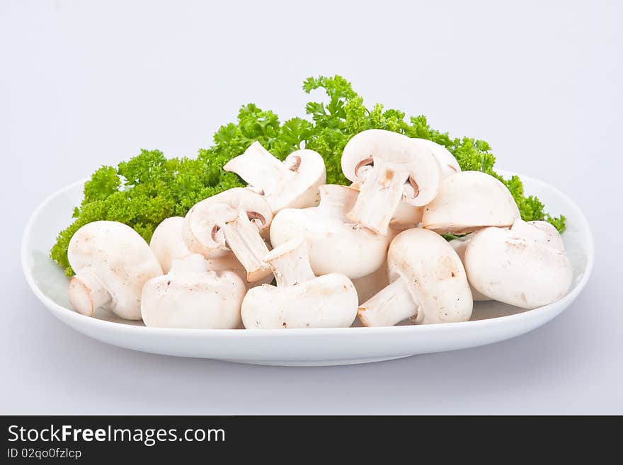 Group of champignons on white plate with parsley. Group of champignons on white plate with parsley