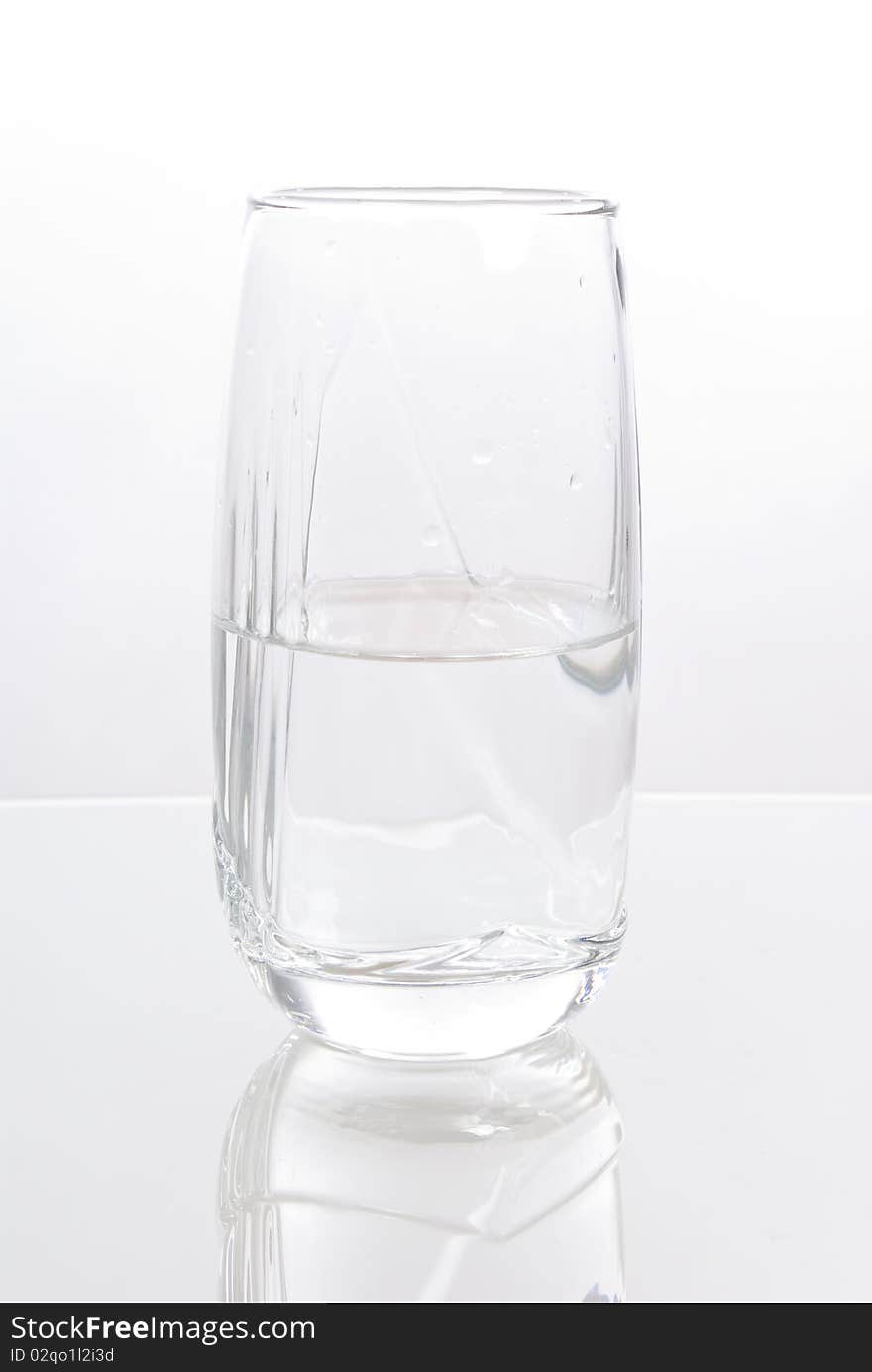 Glass of water half empty isolated on white background