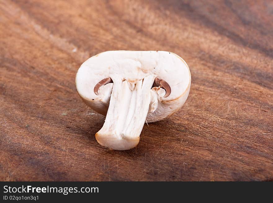 Half fresh champignon on a chopping board. Half fresh champignon on a chopping board