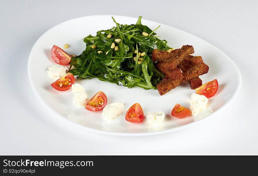 Green endive salad with rusks, feta and tomatoes isolated on a white. Green endive salad with rusks, feta and tomatoes isolated on a white