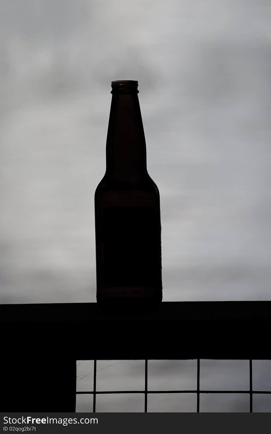 An empty beer bottle silhouetted on a lake. An empty beer bottle silhouetted on a lake