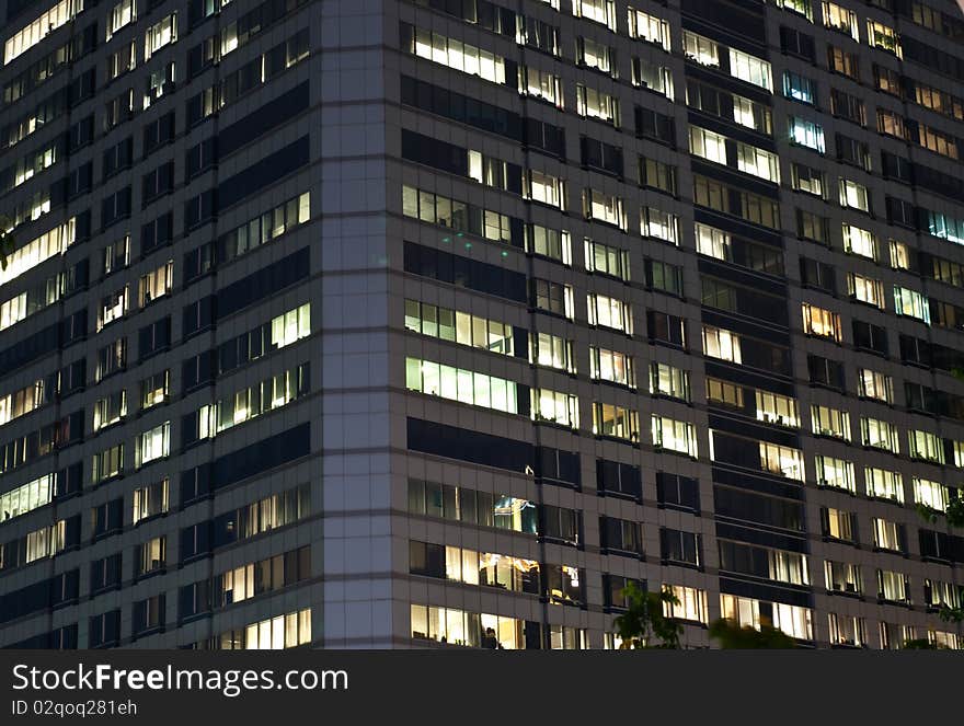 Modern office building at night. Interior is visible through glass windows.