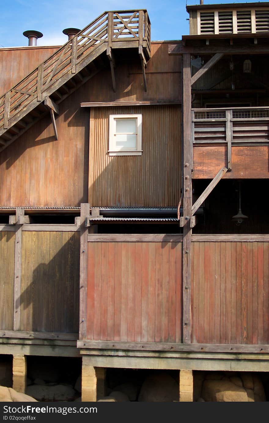 A vertical shot of an old, rundown cannery row building with a single window. A vertical shot of an old, rundown cannery row building with a single window