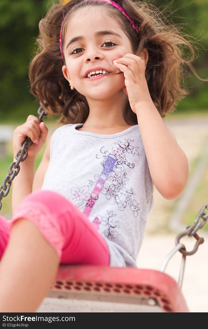 Lovely girl on a swing in the park