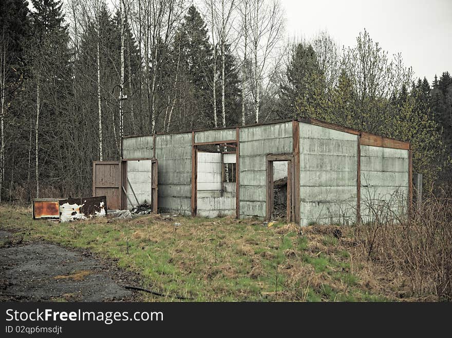 Abandoned ruined house in the woods, moody cloudy weather.