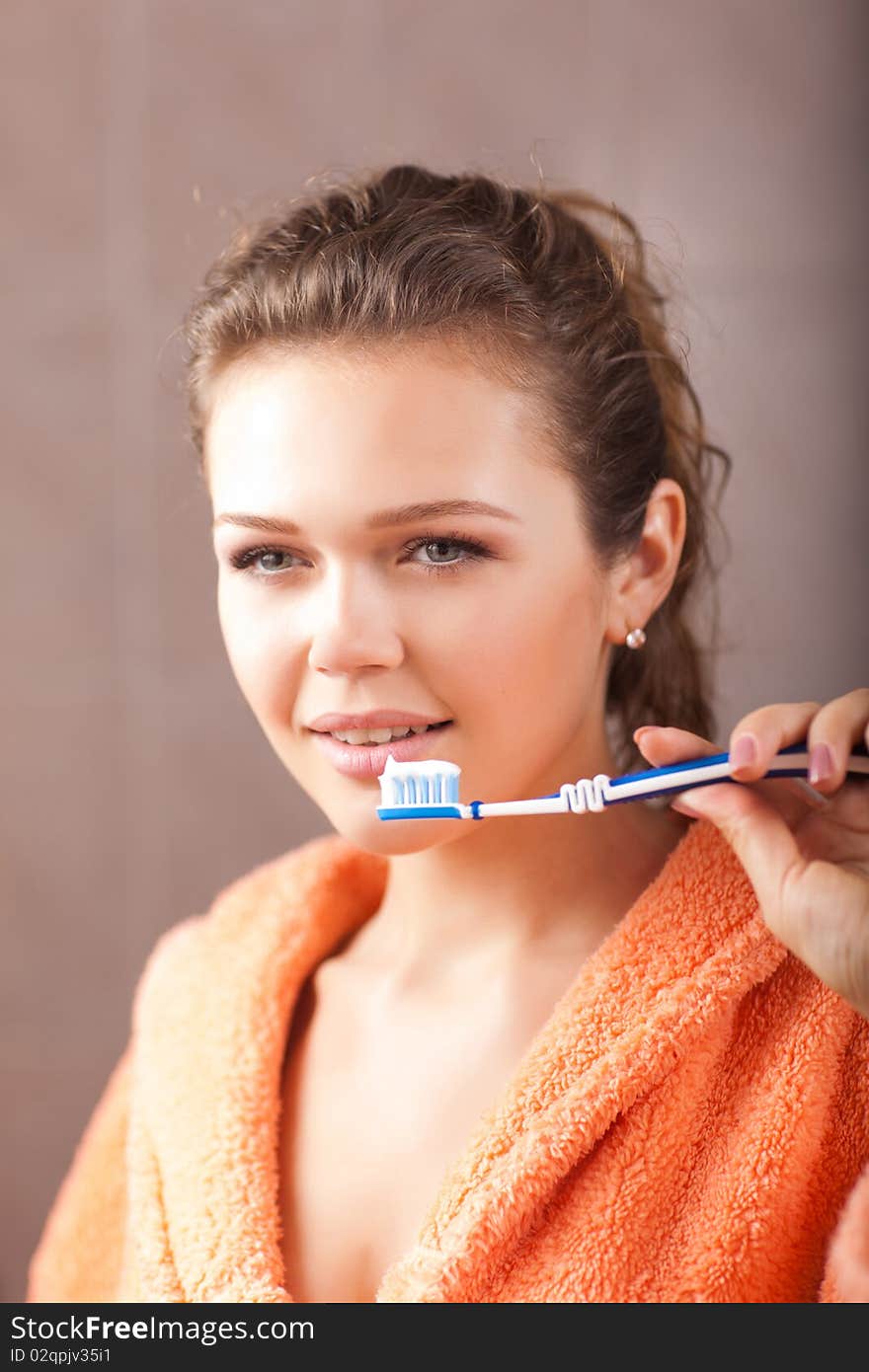 Woman in bath brushing her teeth and looking at the mirror. Woman in bath brushing her teeth and looking at the mirror