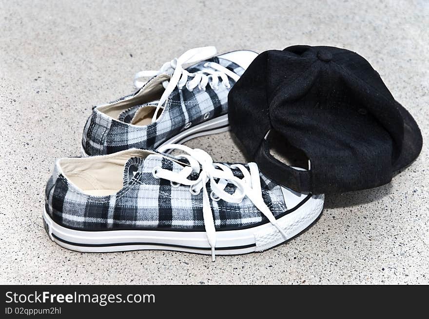 A pair of modern canvas shoes and a cap. A pair of modern canvas shoes and a cap.