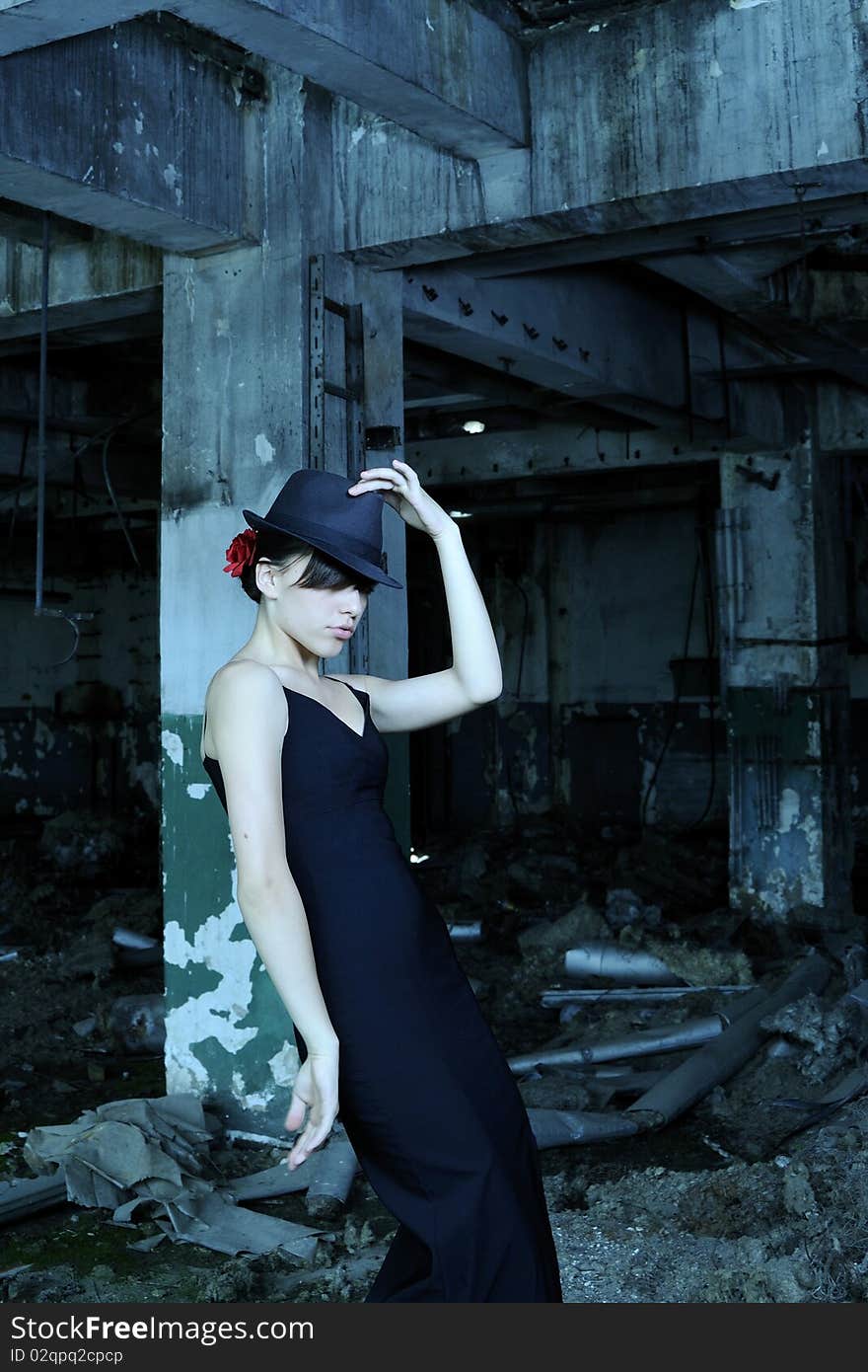 White teen showing black hat and dancing in demolished construction. White teen showing black hat and dancing in demolished construction