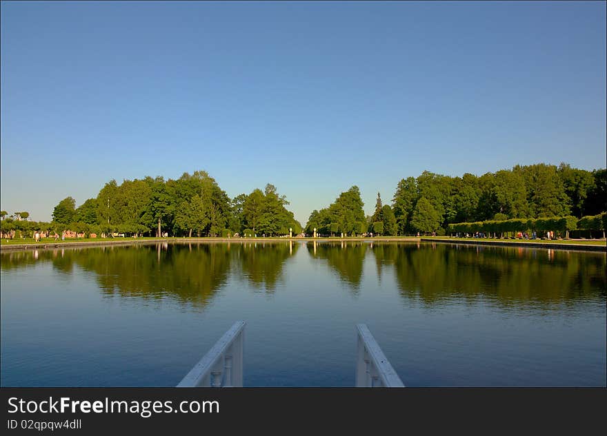 Lake in the summer park. Trees and sky.