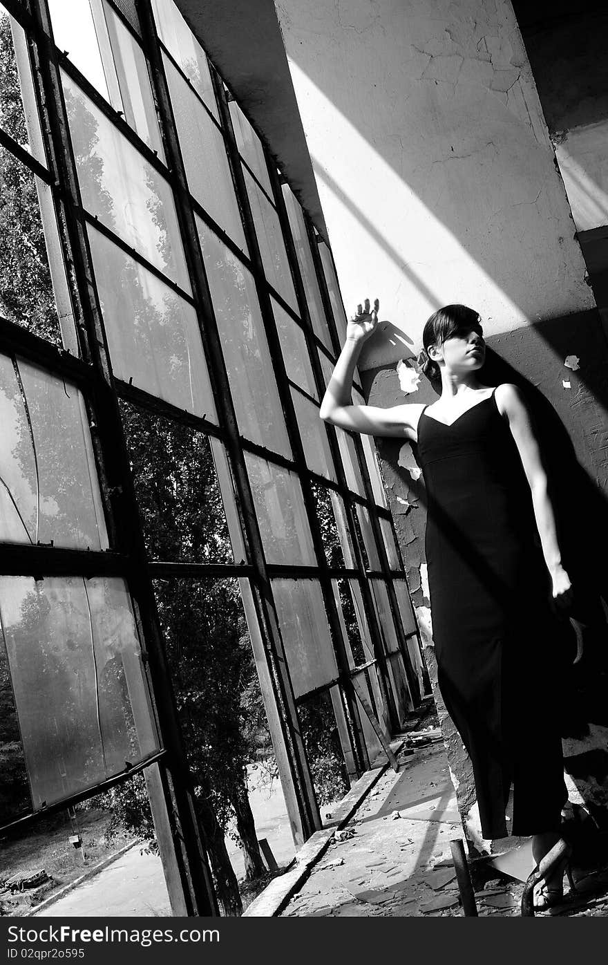 Black and white photography with beautiful teenager girl presenting elegant collection in demolished construction, broken windows in background. Black and white photography with beautiful teenager girl presenting elegant collection in demolished construction, broken windows in background