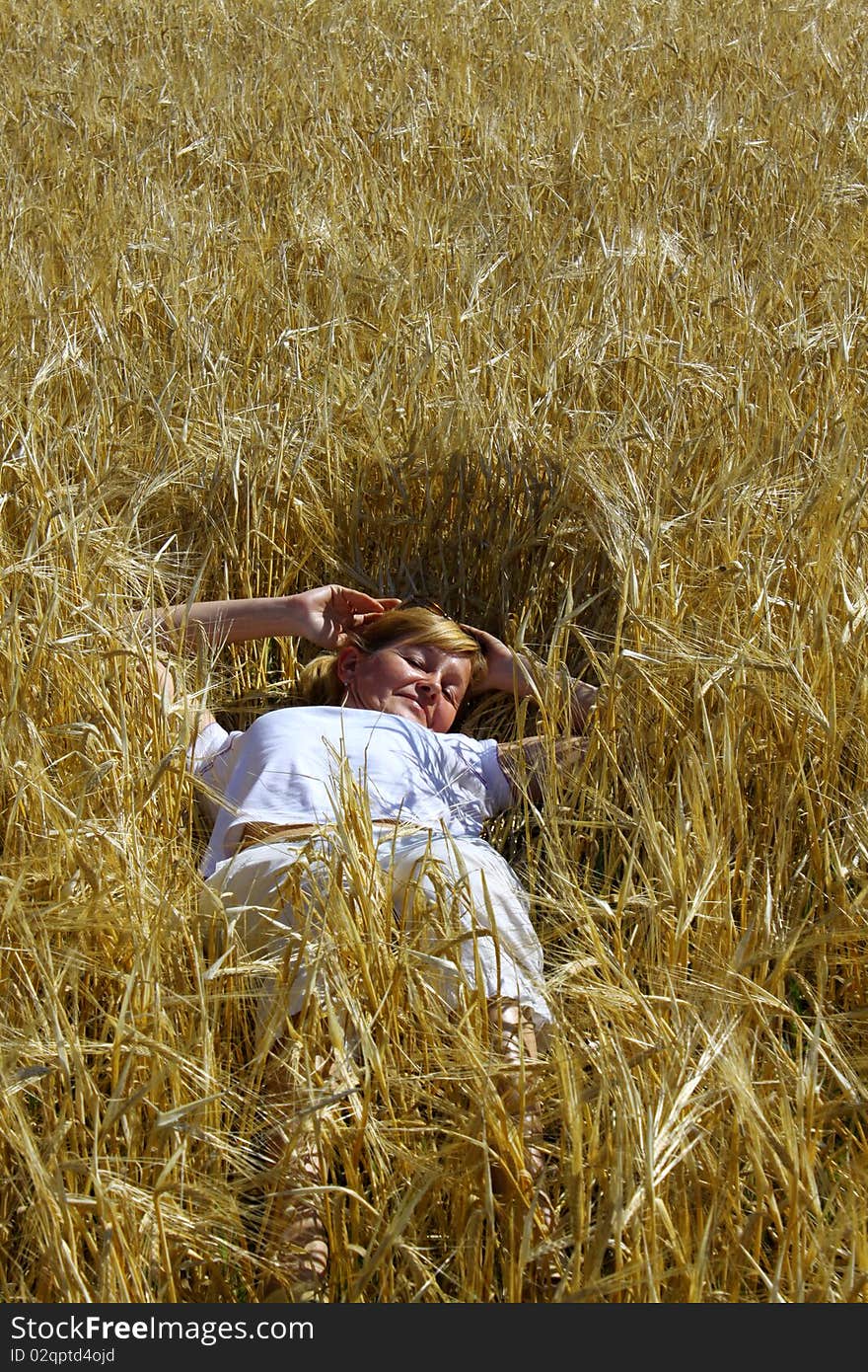 Woman lying in a wheaten field. Woman lying in a wheaten field