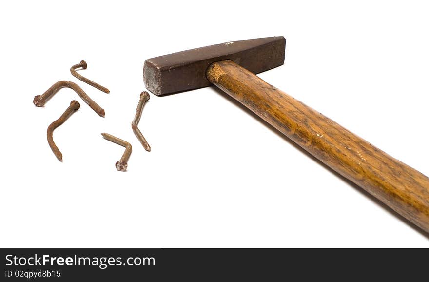 The old hammer and rusty nails bent on a white background. The old hammer and rusty nails bent on a white background.