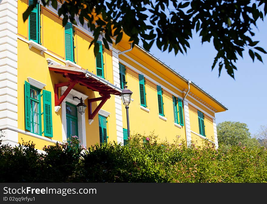 Green door and windows in a yellow house