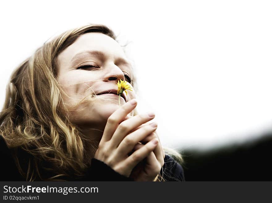 Happy girl inhaling the essence of a beautiful flower. Happy girl inhaling the essence of a beautiful flower.