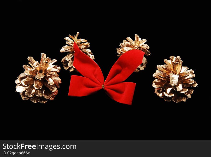 Christmas decoration from four fir-cone and a red bow
on black background. Christmas decoration from four fir-cone and a red bow
on black background.