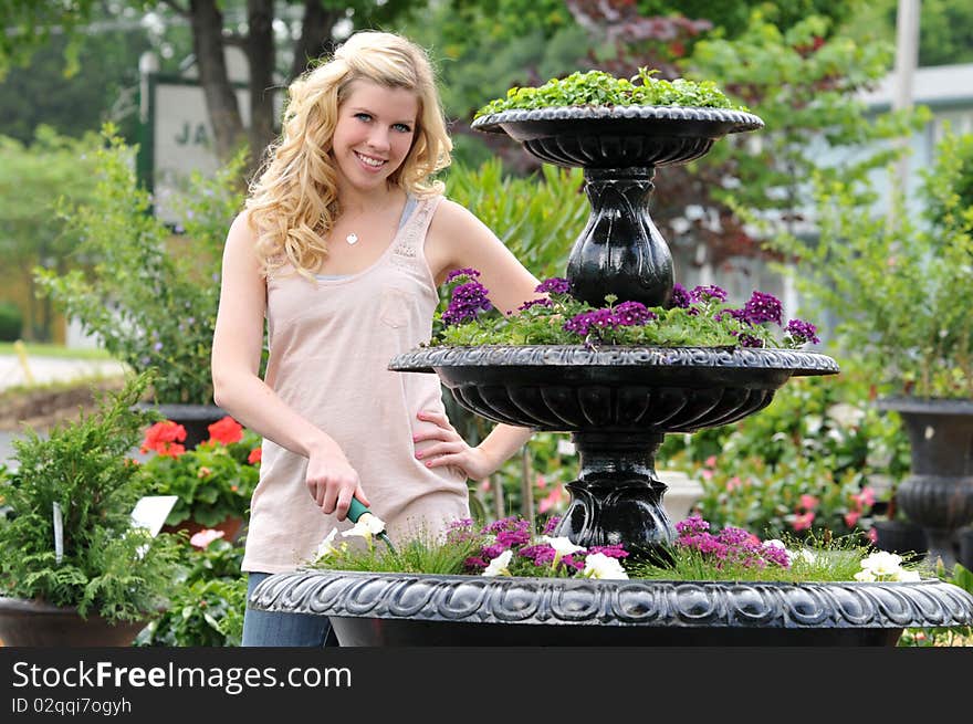 Beautiful young blond in the garden with a colorful background