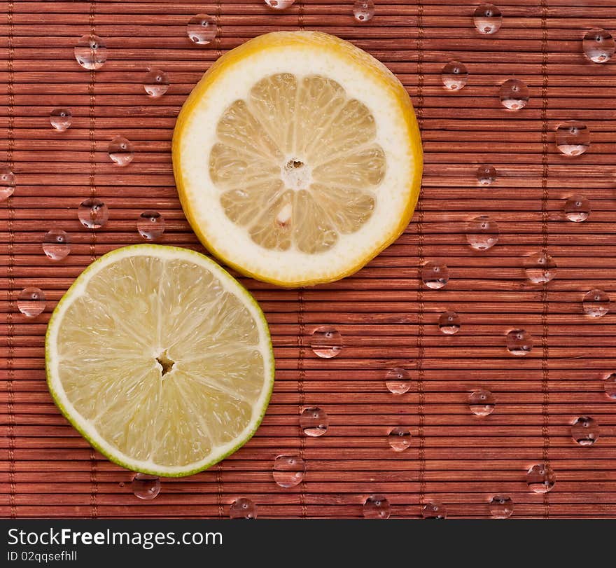 Key Lime and Lemon Slice on Bamboo with Water Beads. Key Lime and Lemon Slice on Bamboo with Water Beads