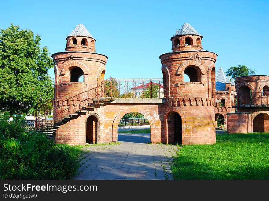 Brick towers connected by the bridge in park