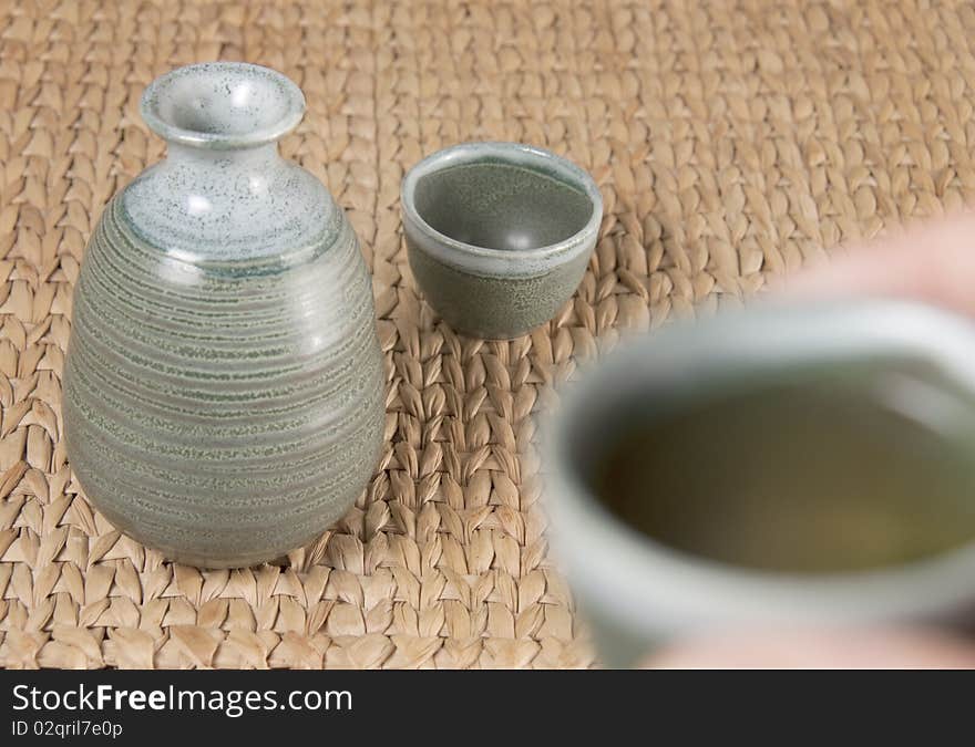 A pottery tea set with one cup up