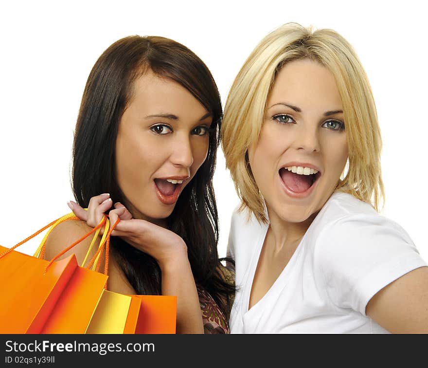 Beautiful blonde and brunette carry their shopping bags together. Beautiful blonde and brunette carry their shopping bags together