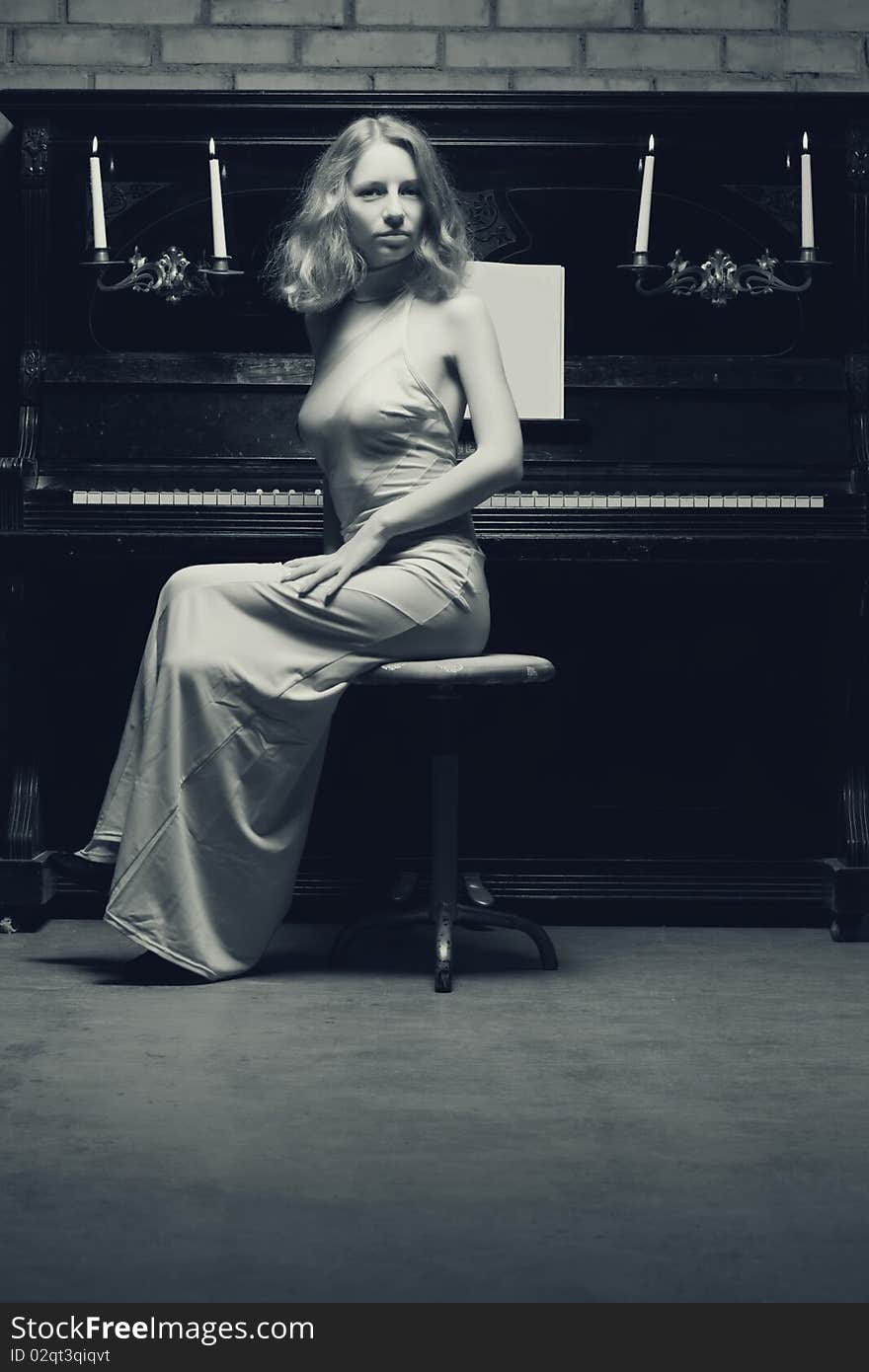 Beautiful young woman playing the piano (black and white photo)