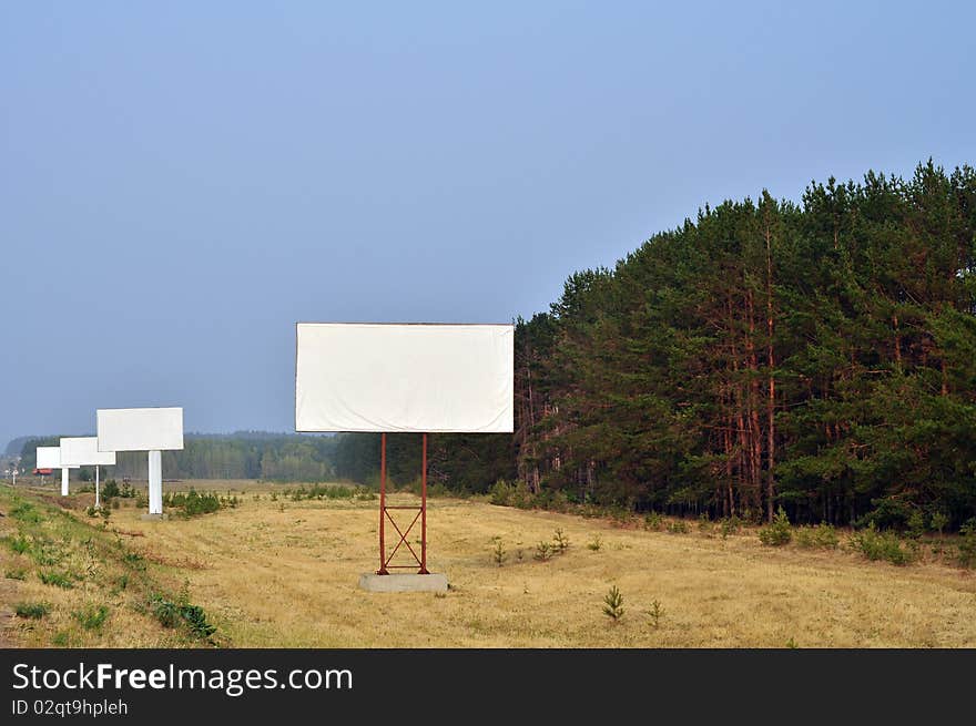 A number of structures along the road, empty, in a forest and sky. A number of structures along the road, empty, in a forest and sky