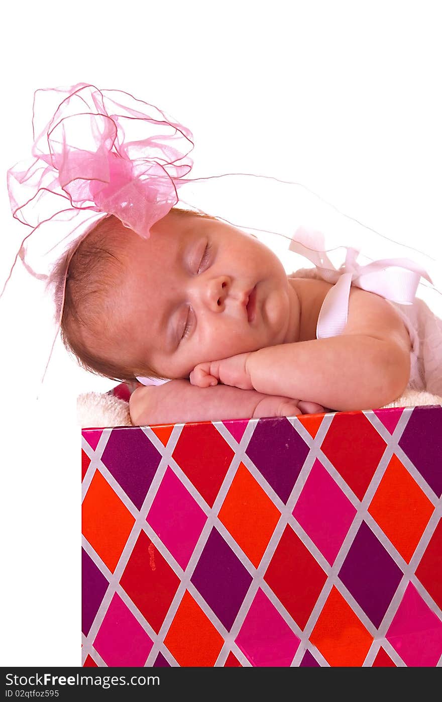 Baby in a colorful gift box with bow on her head. Baby in a colorful gift box with bow on her head.