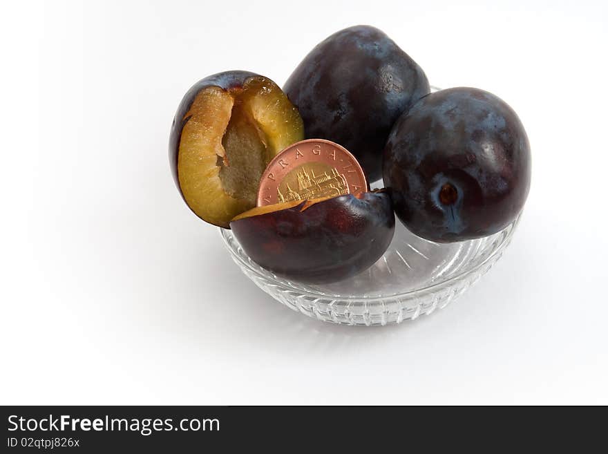 A coin in a plum representing a surprising income, a fruit of hard work. A coin in a plum representing a surprising income, a fruit of hard work.