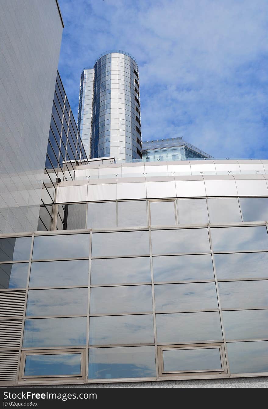 The modern task with a glass tower against the blue sky