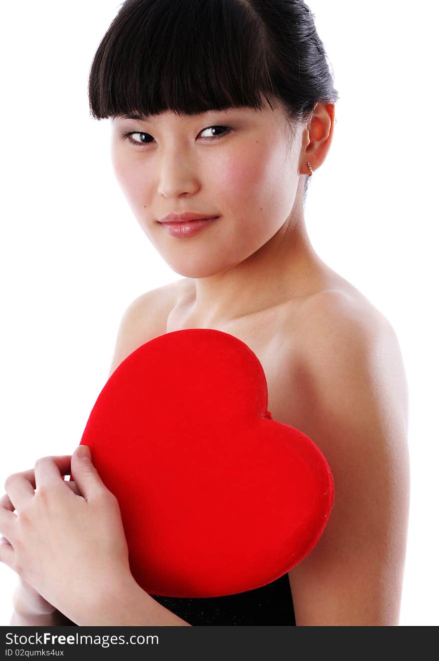 Portrait of a young woman holding a red heart and day dreaming over white background. Portrait of a young woman holding a red heart and day dreaming over white background