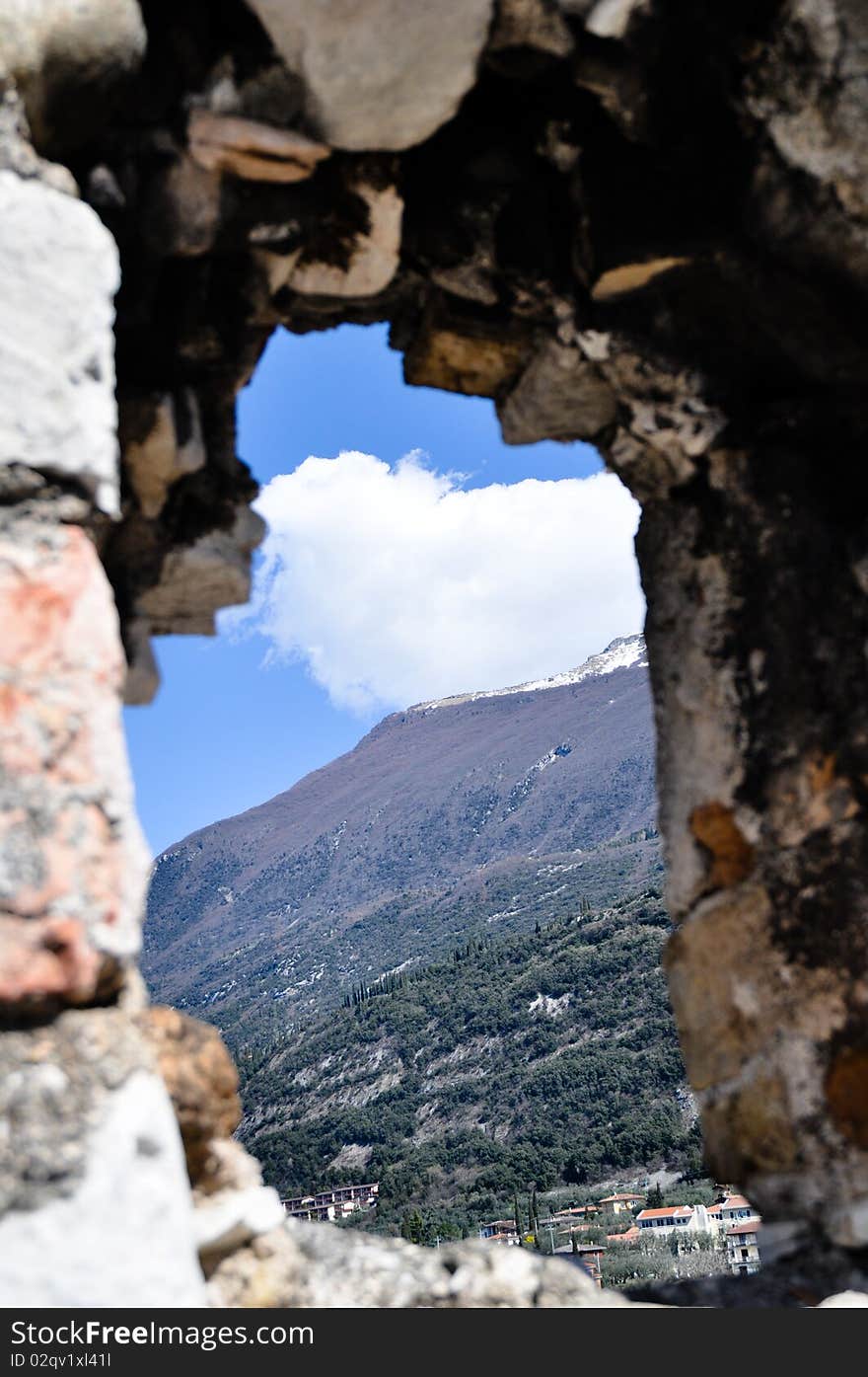 View of the mountains through the hole in the wall of the castle. View of the mountains through the hole in the wall of the castle.