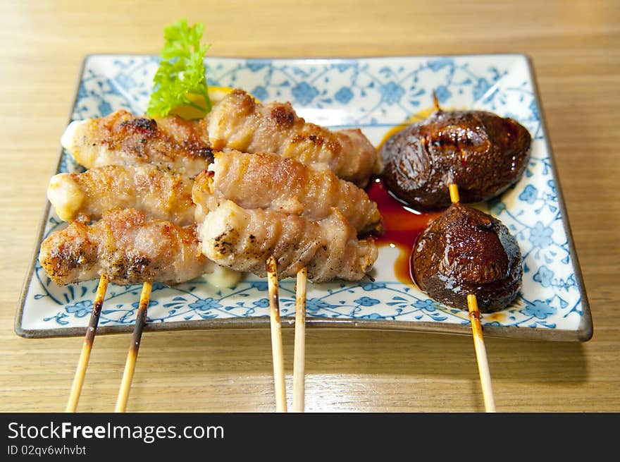 A plate of delicious and skewered chicken, pork and mushroom, coated with cheese, wrapped and barbecued, then served in a Japanese restaurant, a fine delicacy here in the local food scene. A plate of delicious and skewered chicken, pork and mushroom, coated with cheese, wrapped and barbecued, then served in a Japanese restaurant, a fine delicacy here in the local food scene.