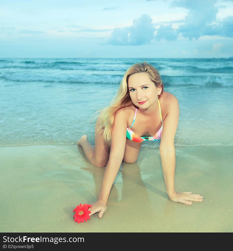 Beautiful young woman with flower at the beach. Beautiful young woman with flower at the beach