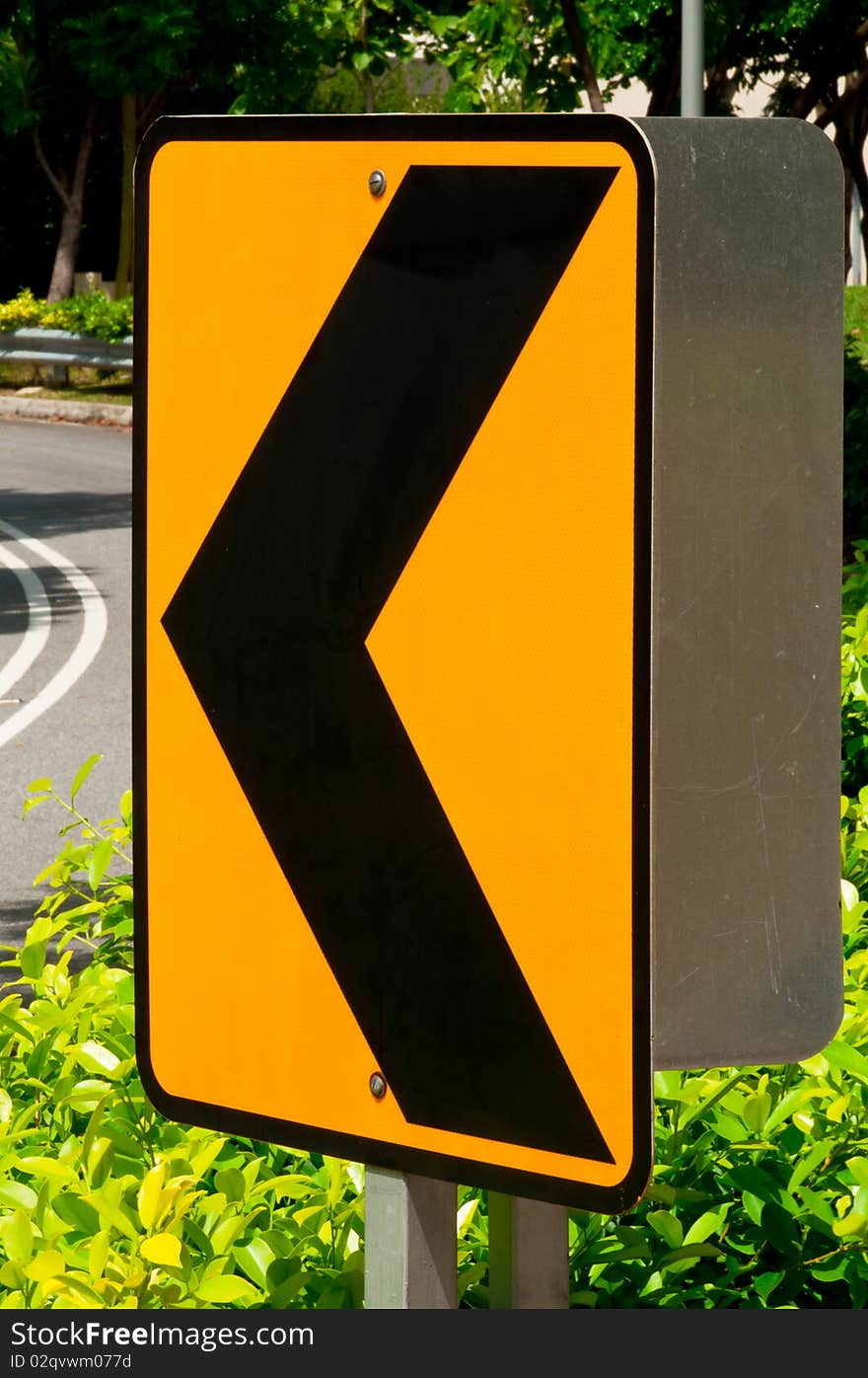 A Sharp Left Turn Sign on Road Curve. A Sharp Left Turn Sign on Road Curve