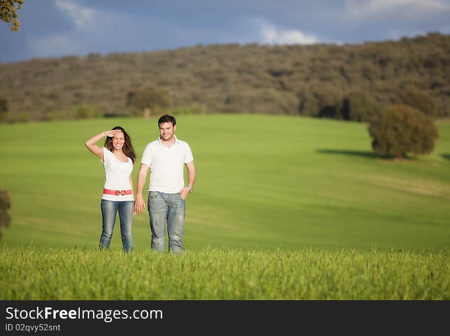 Young beautiful couple hand by hand isolated on natural green background. Young beautiful couple hand by hand isolated on natural green background.