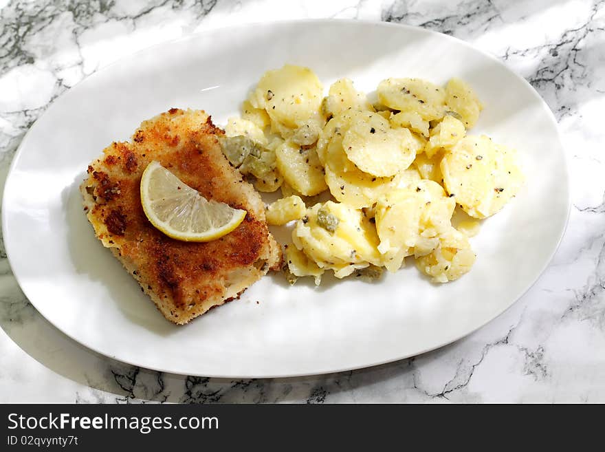 Coalfish in breadcrumb coating wraps up, in addition there is a salad from potatoes with gherkins and mayonnaise. Coalfish in breadcrumb coating wraps up, in addition there is a salad from potatoes with gherkins and mayonnaise.