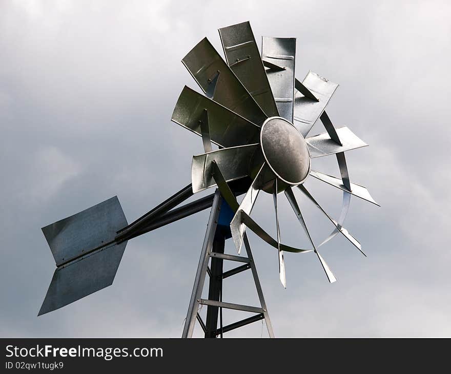 Reproduction of an aluminum windmill against an overcast sky