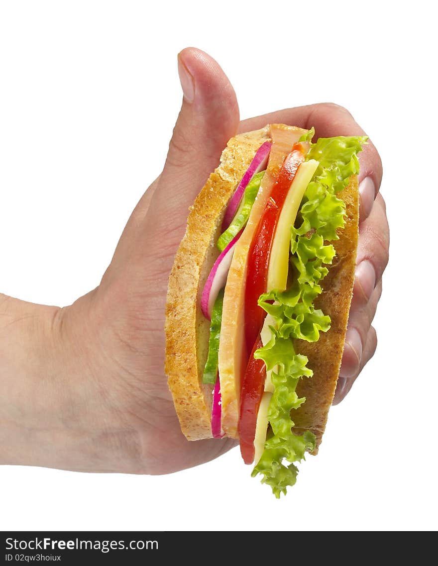 Sandwich with ham, tomato, radish, cucumber and cheese in the hand isolated over white background. Sandwich with ham, tomato, radish, cucumber and cheese in the hand isolated over white background