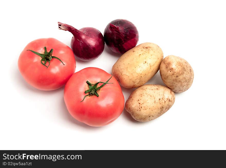 Collection of vegetables: potatoes, tomatoes and onions, shot on a white background